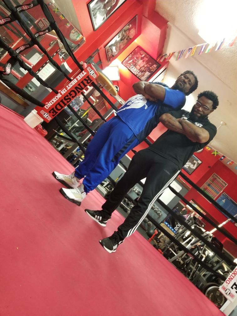 Two men standing in a gym with a sign that says ringside
