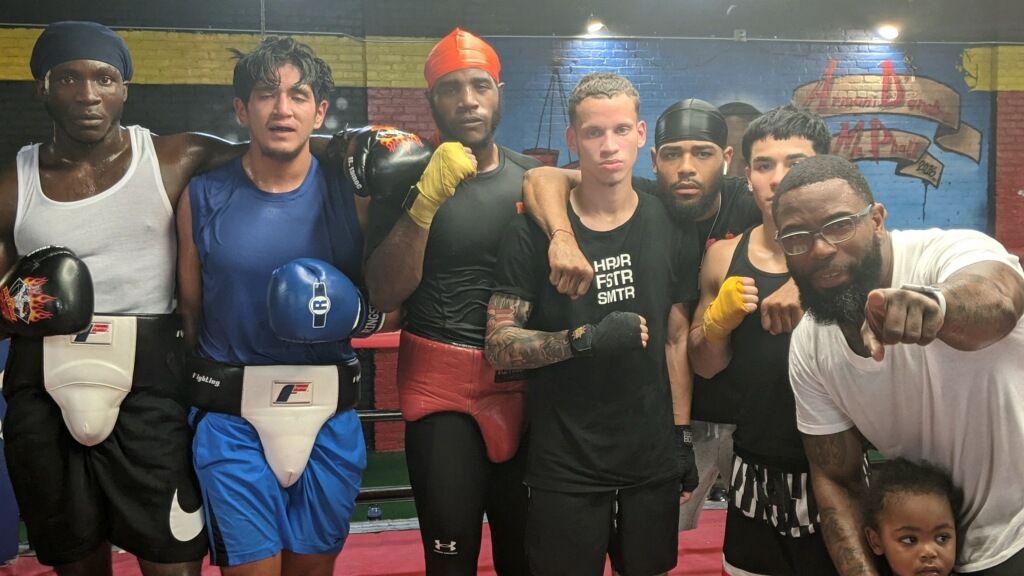 A group of men are posing for a picture in a boxing ring.