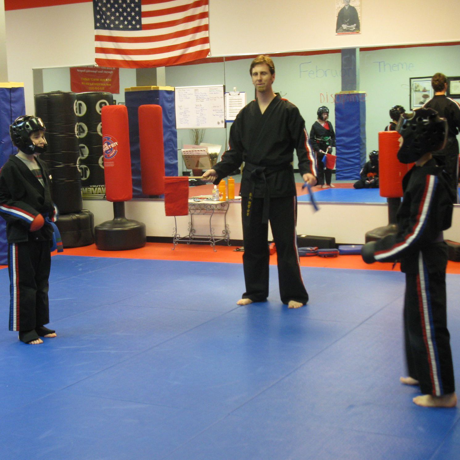 A group of people are practicing martial arts in a gym