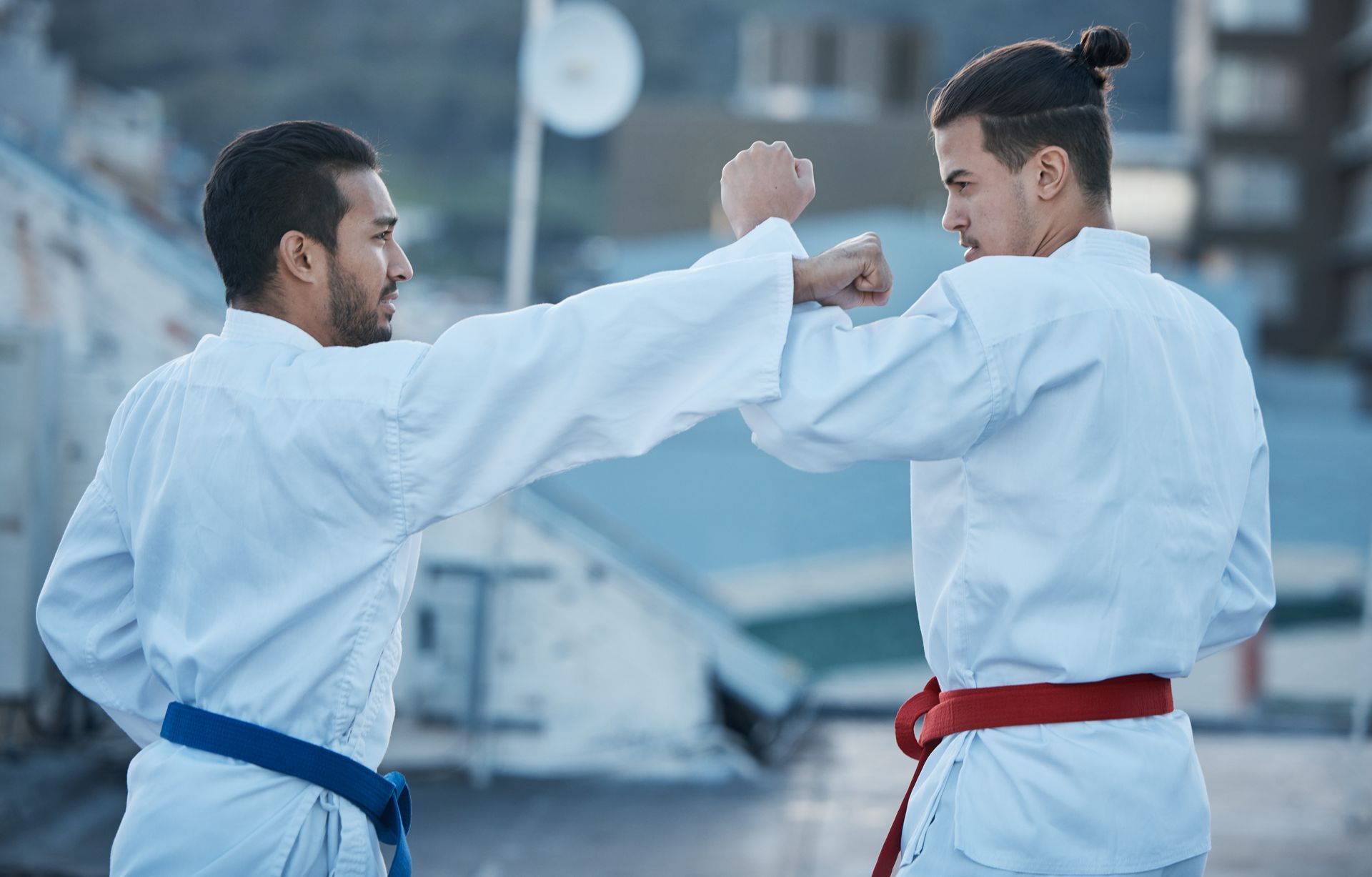 Two men are practicing karate on a rooftop.