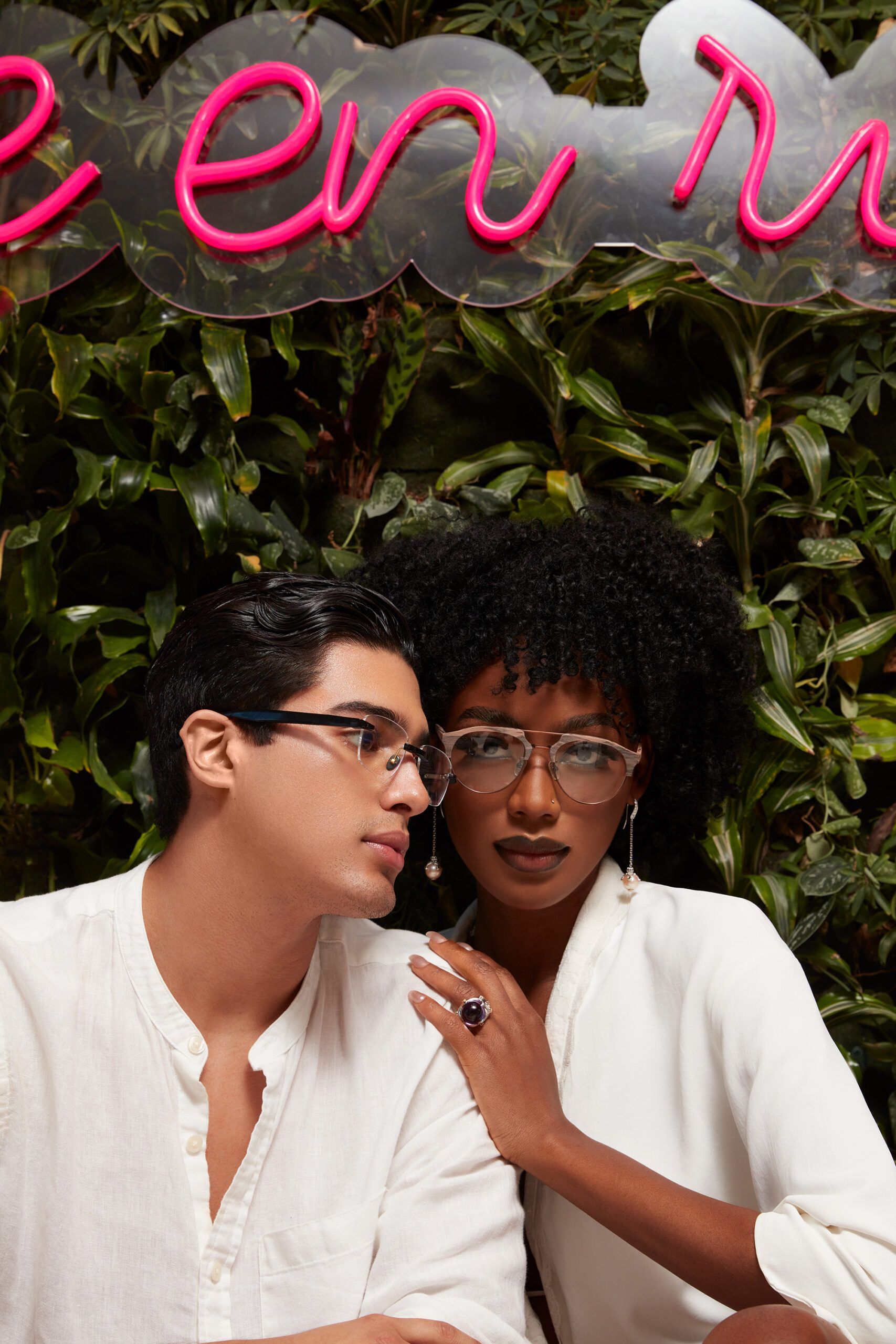 A man and a woman are sitting in front of a neon sign that says zen