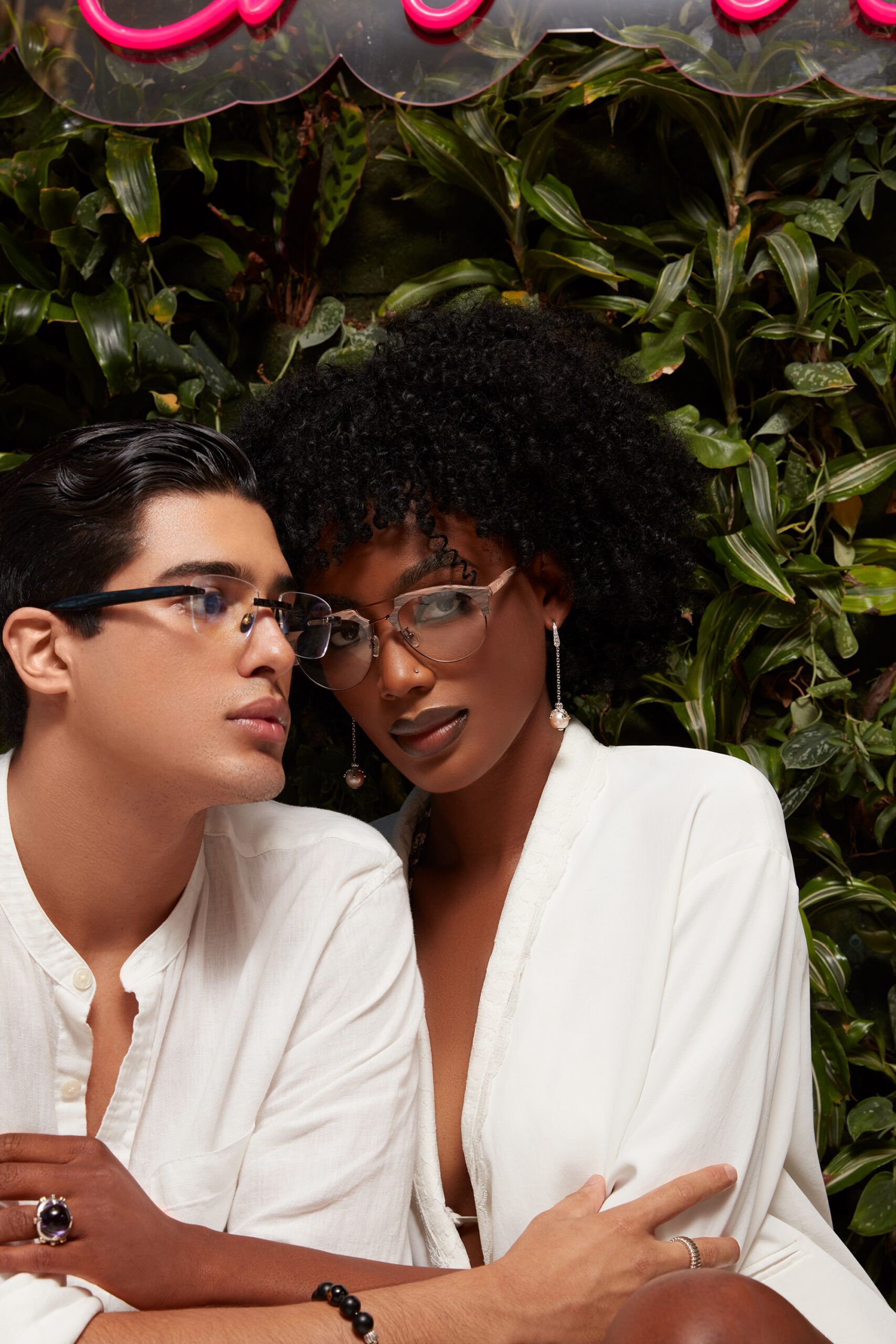 A man and a woman wearing glasses are sitting next to each other