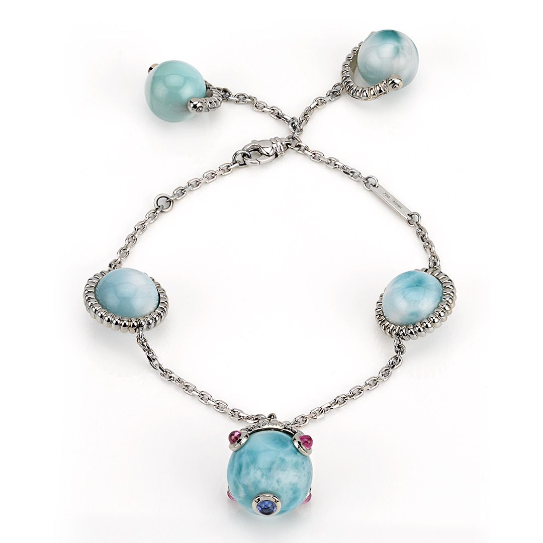 A silver bracelet with blue beads on a chain
