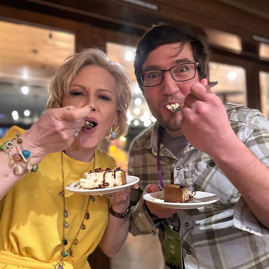 A man and a woman are eating a piece of cake