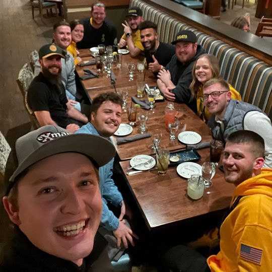 A group of people are sitting around a table in a restaurant.