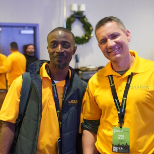 Two men wearing yellow shirts with augusta written on them
