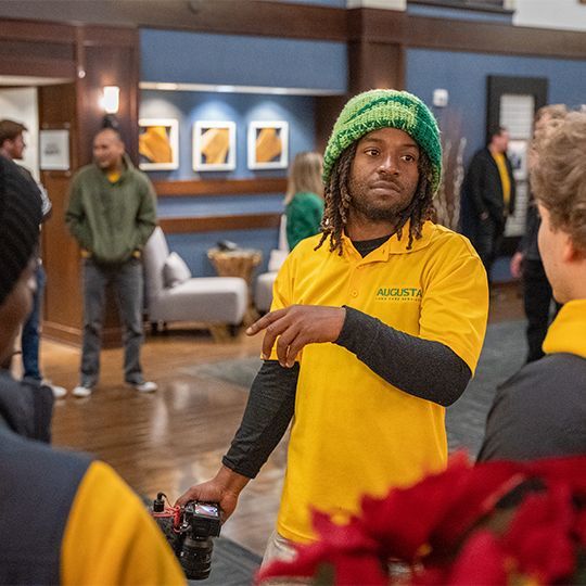 A man in a yellow shirt that says augusta on it