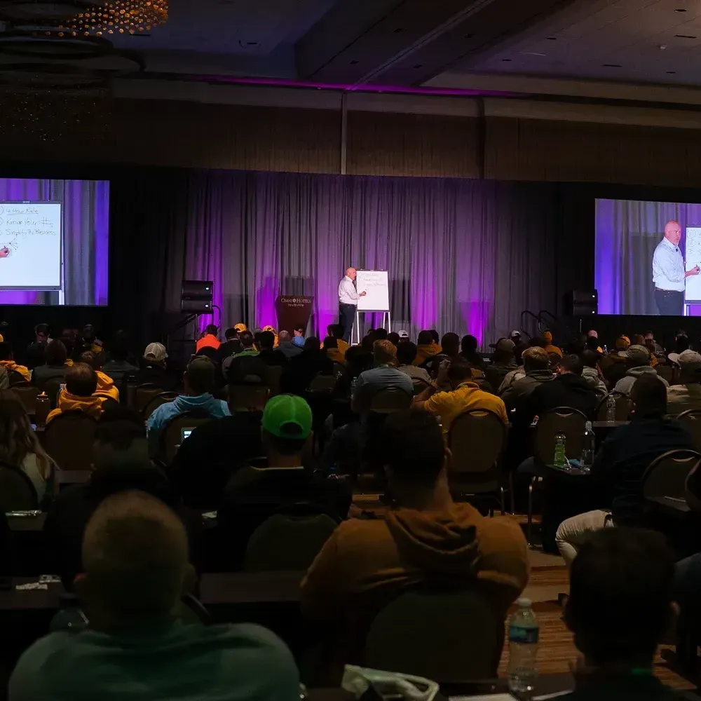 A man is giving a presentation to a large group of people in a conference room.