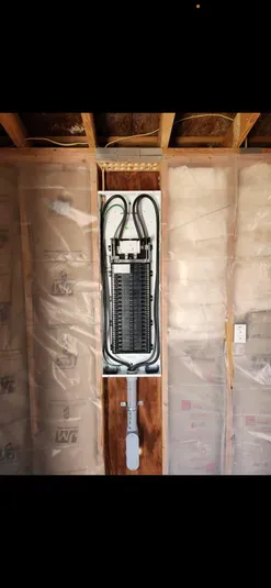 Electrical panel installed in a wall with insulation.