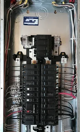 An open electrical panel with circuit breakers and wires.