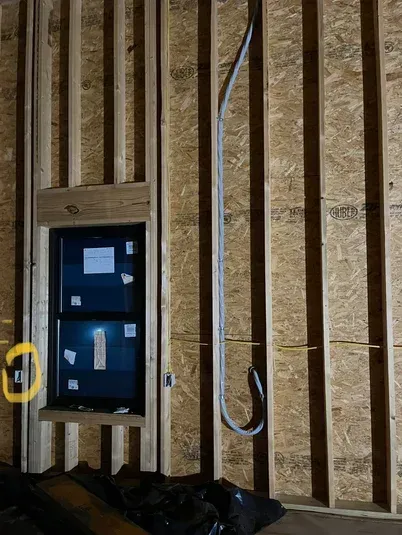 Interior framing with a window and electrical conduit.