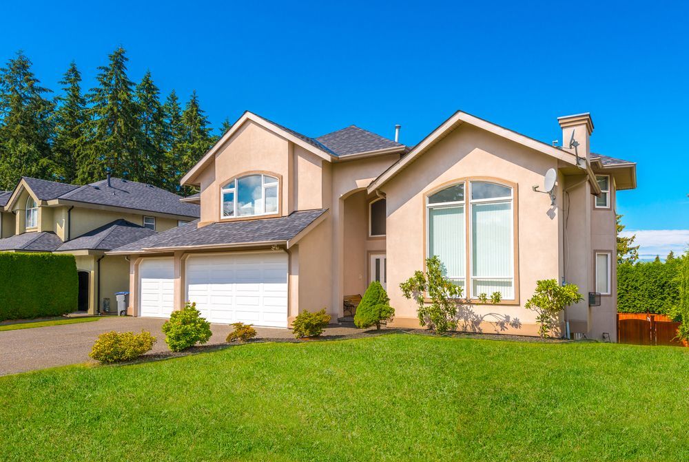 A Large House With Two Garages is Sitting on Top of a Lush Green Lawn — Key2 Conveyancing In Tea Gardens, NSW