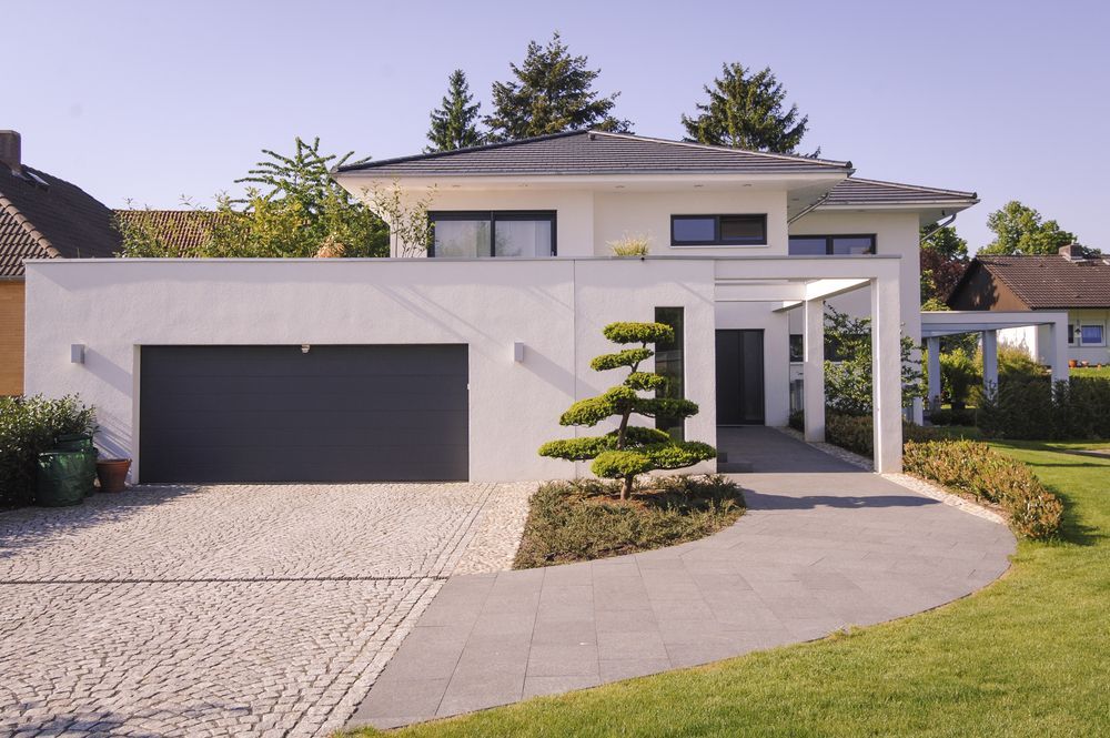 A Large White House With a Black Garage Door — Key2 Conveyancing In Tea Gardens, NSW