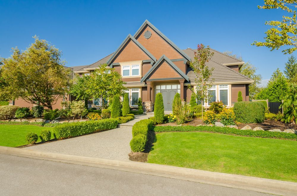 A Large Brick House With a Lush Green Lawn in Front of It — Key2 Conveyancing In Moree, NSW