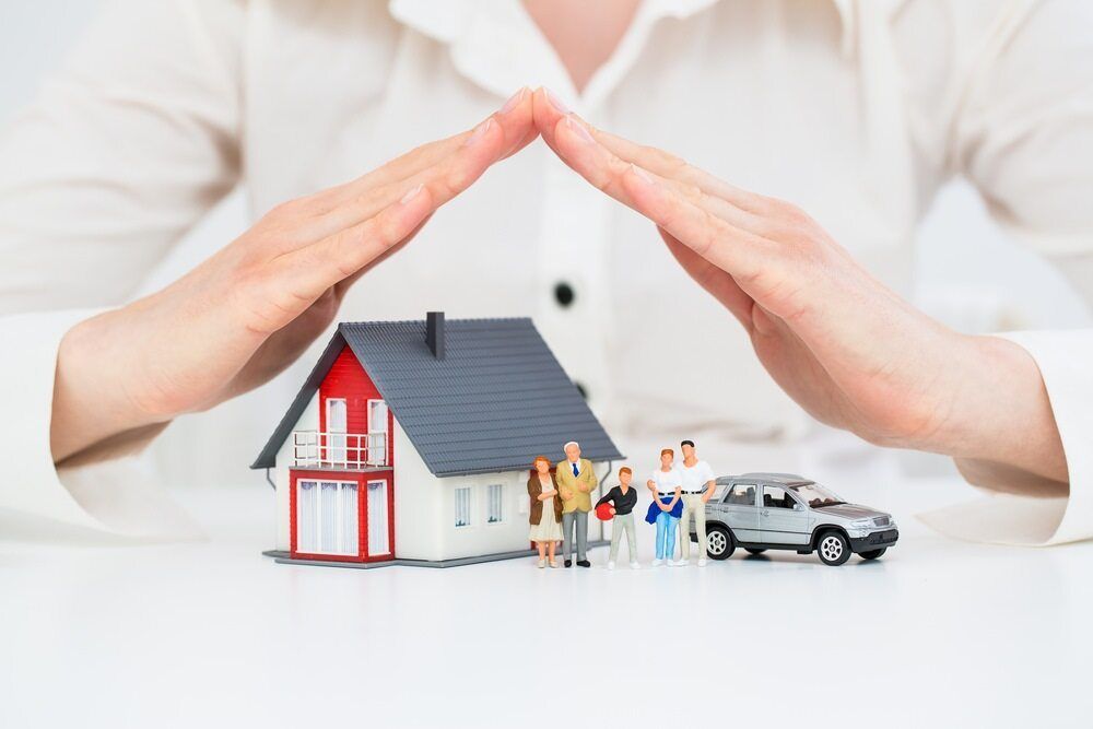 A Woman is Covering a House and a Car With Her Hands — Key2 Conveyancing In Moree, NSW