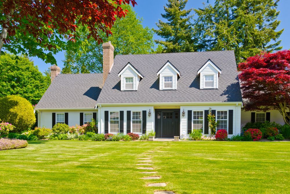 A Large White House With a Lush Green Lawn in Front of It — Key2 Conveyancing In Forster, NSW