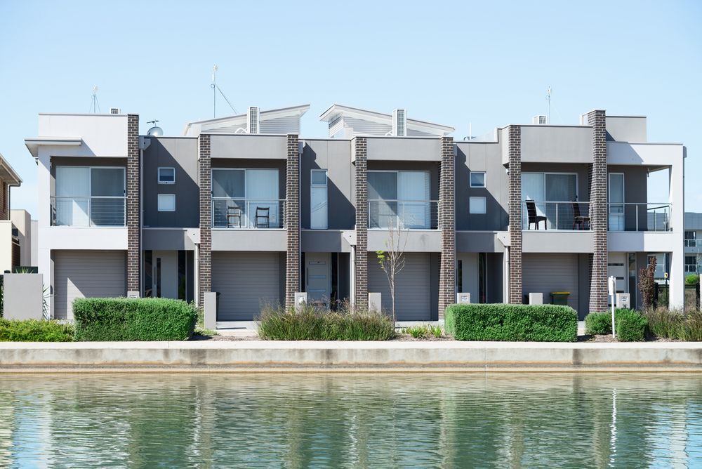 A Row of Houses Next to a Body of Water — Key2 Conveyancing In Hallidays Point, NSW