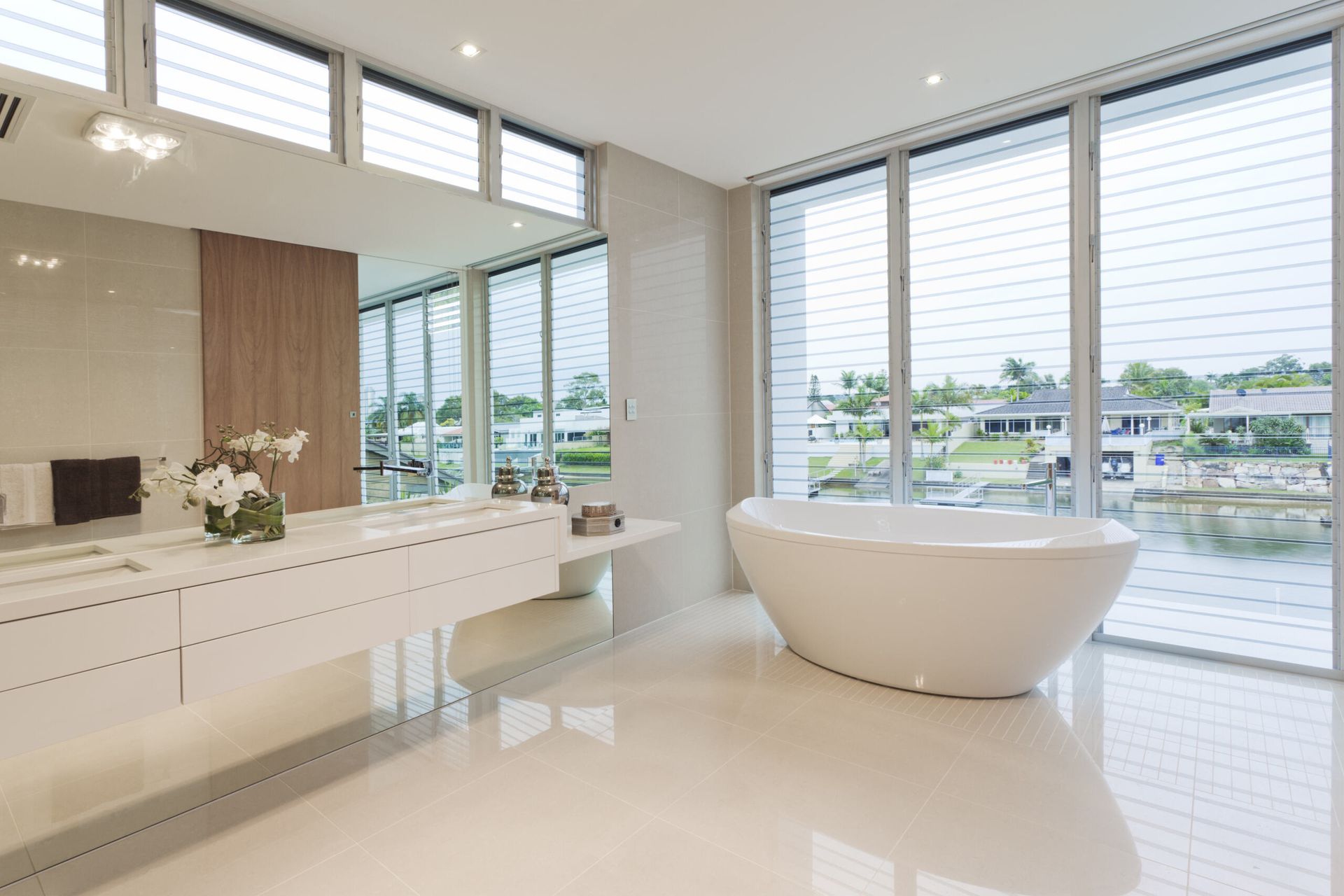 A Bathroom With a Tub, Sink, Mirror and Large Windows — Key2 Conveyancing In Forster, NSW