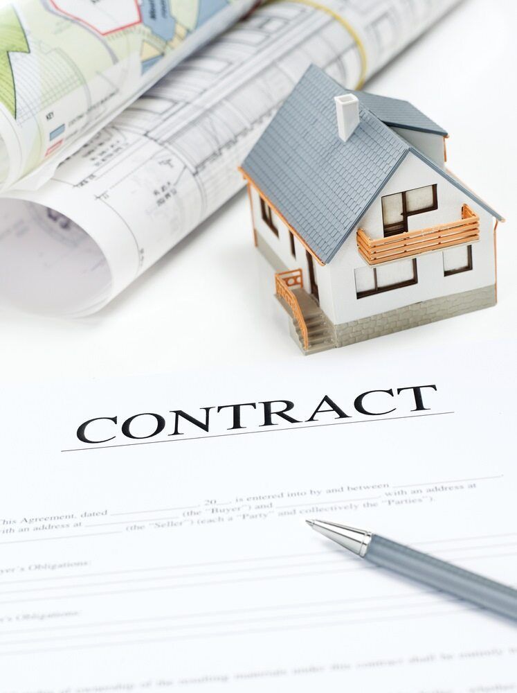 A Model House Sits on Top of a Contract Next to a Pen — Key2 Conveyancing In Tuncurry, NSW