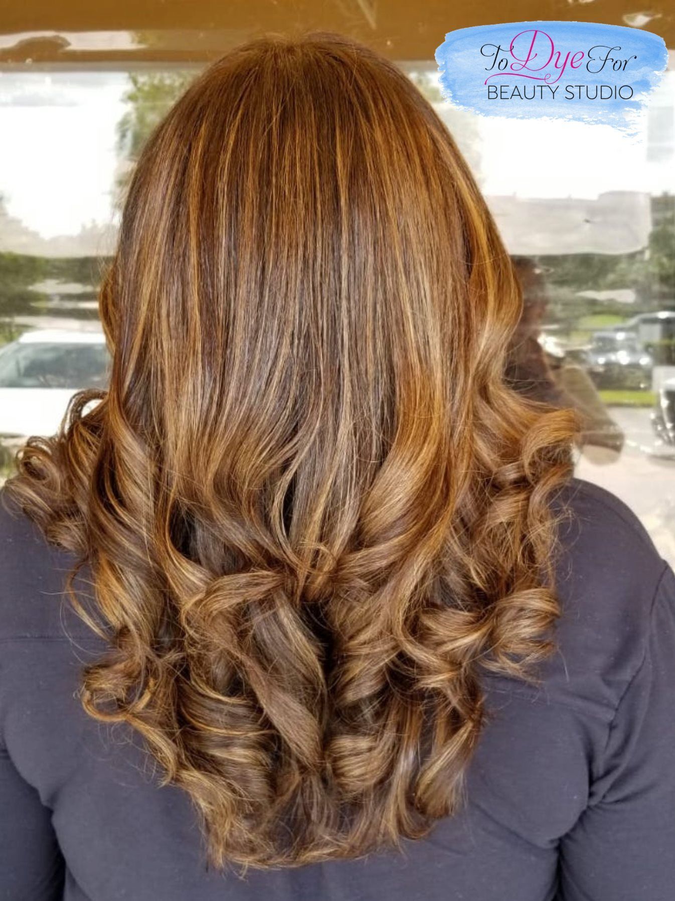 A woman with long brown hair is wearing a black shirt.