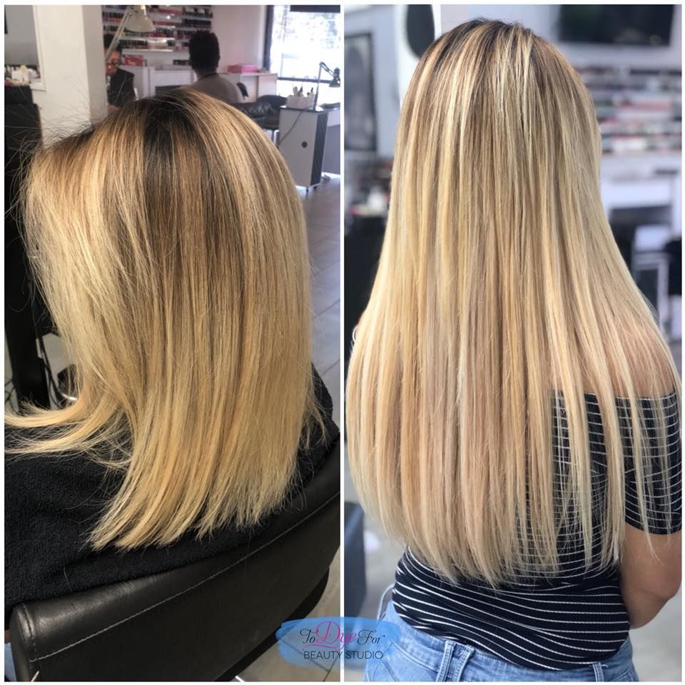 A woman with long blonde hair is sitting in a chair in a salon.