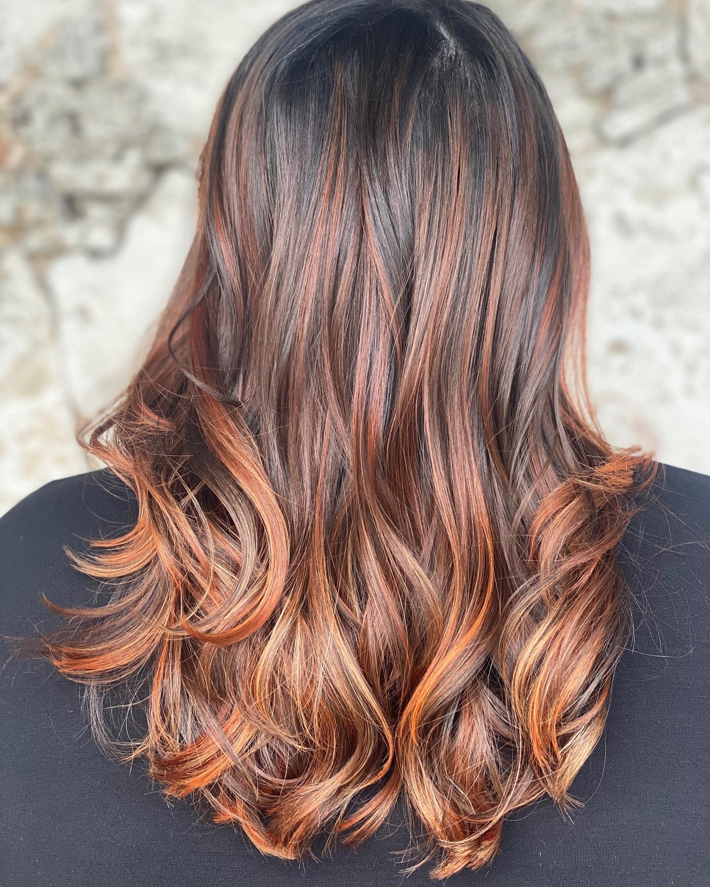 A woman with long brown hair is wearing a black shirt.