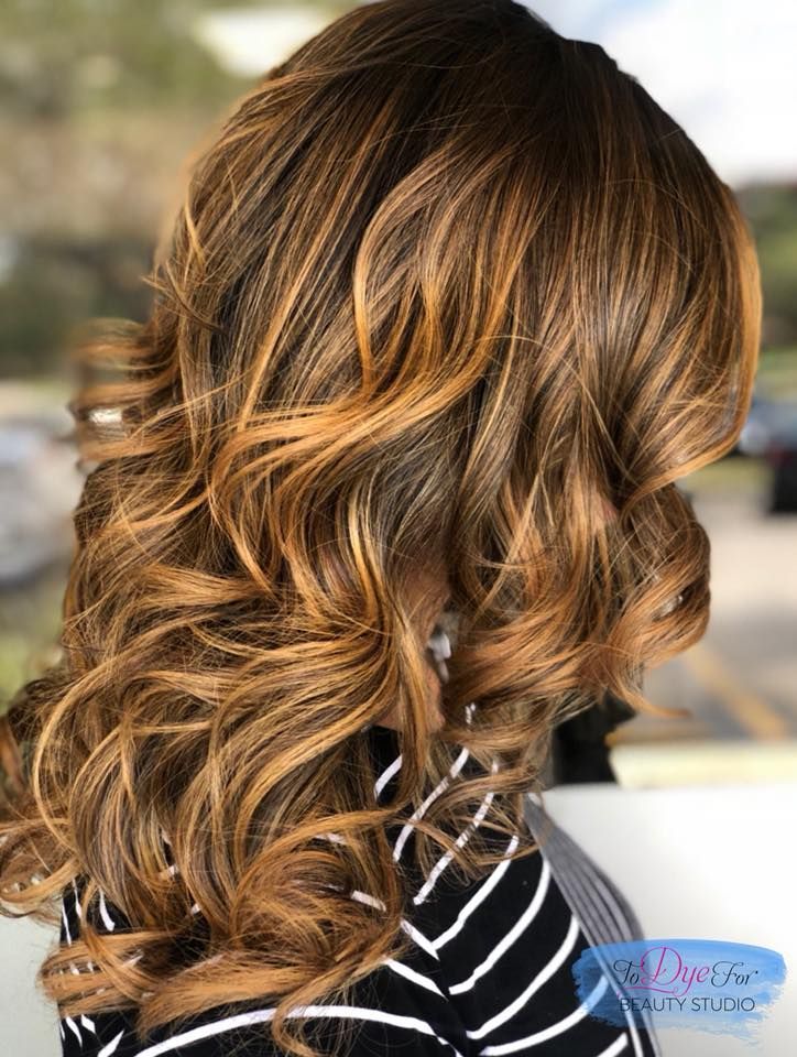 A woman with long brown hair is wearing a black and white striped shirt.