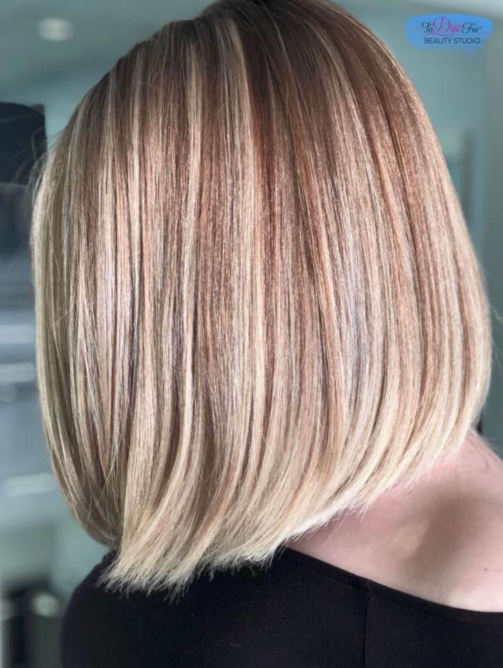 A woman with blonde hair is wearing a black shirt.