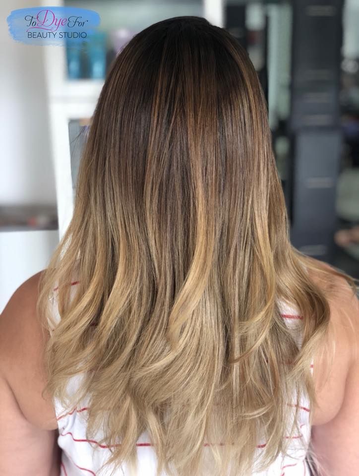 The back of a woman 's head with long blonde hair.