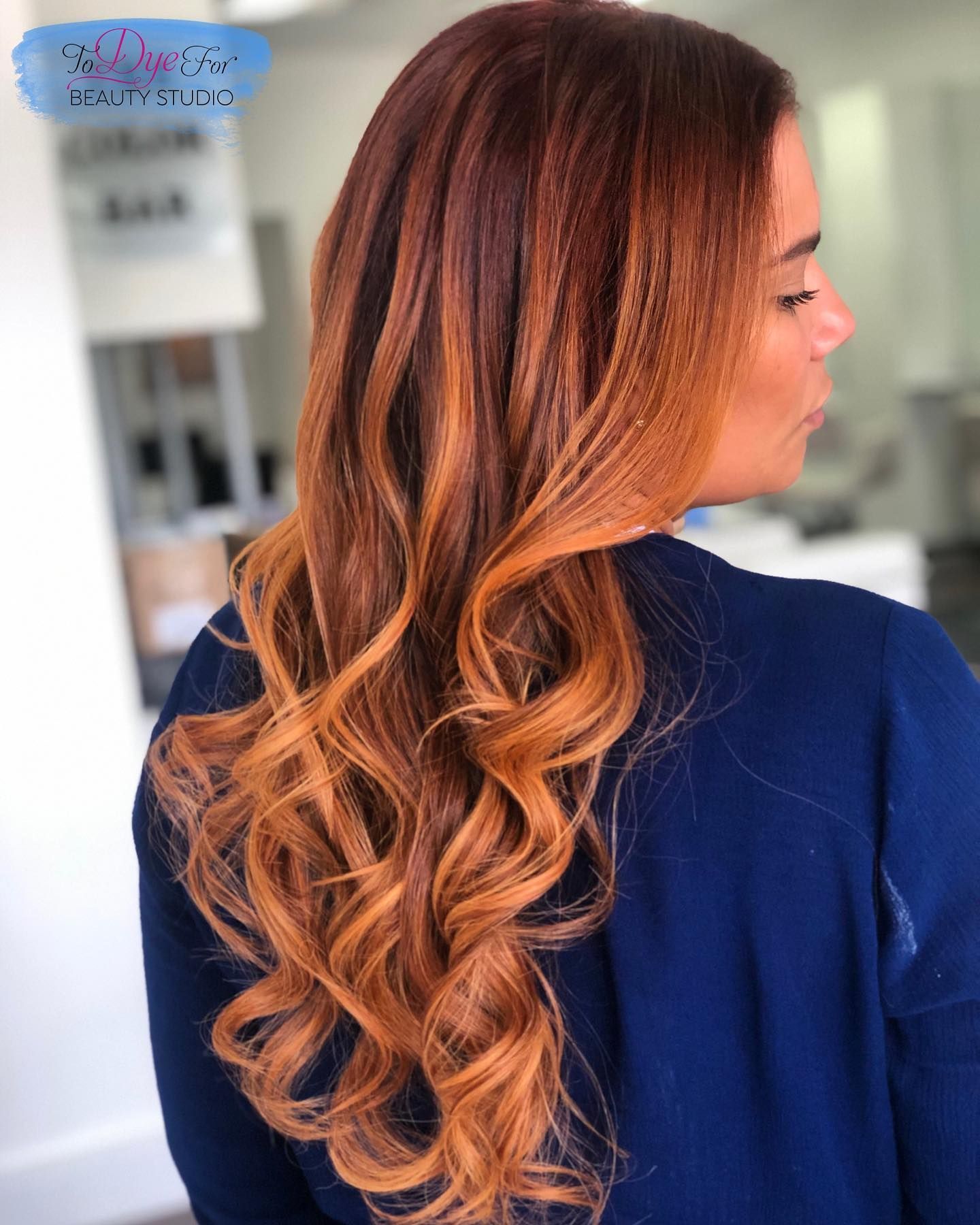 A woman with long brown hair is wearing a blue shirt.