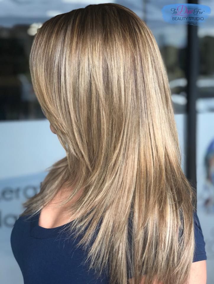 A woman with long blonde hair is wearing a blue shirt