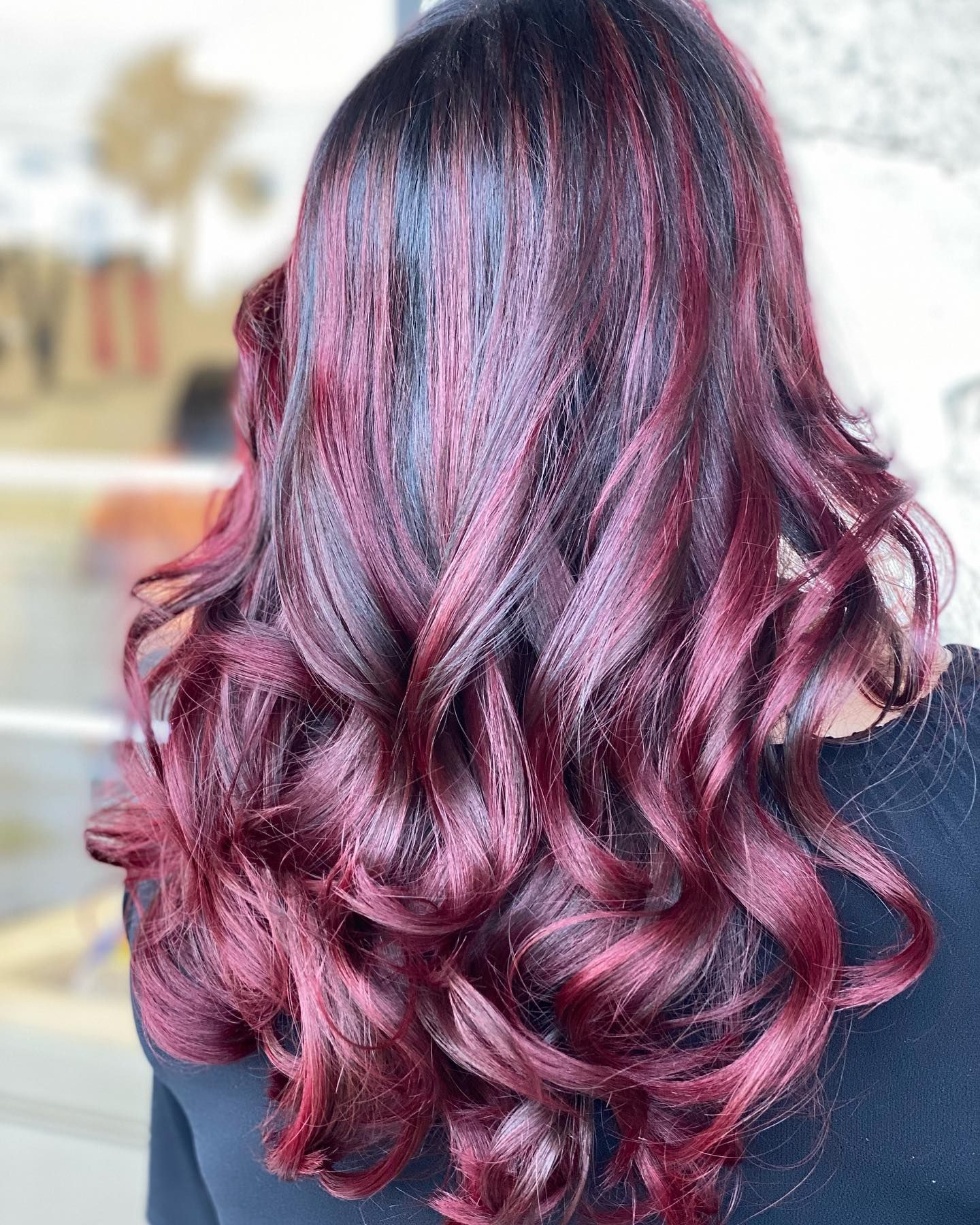 A woman with long red hair is wearing a black shirt.