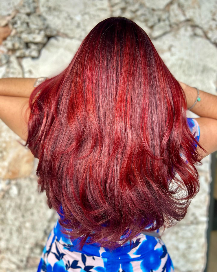 A woman with long red hair is wearing a blue dress.