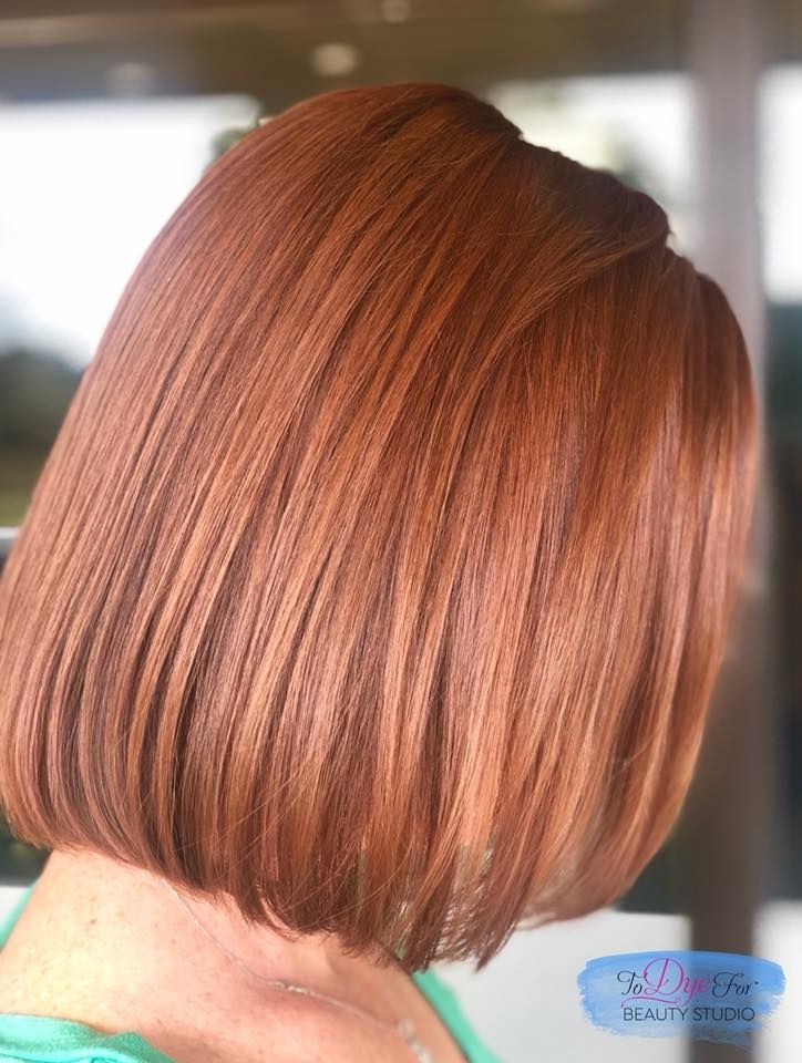 A woman with red hair is wearing a green shirt