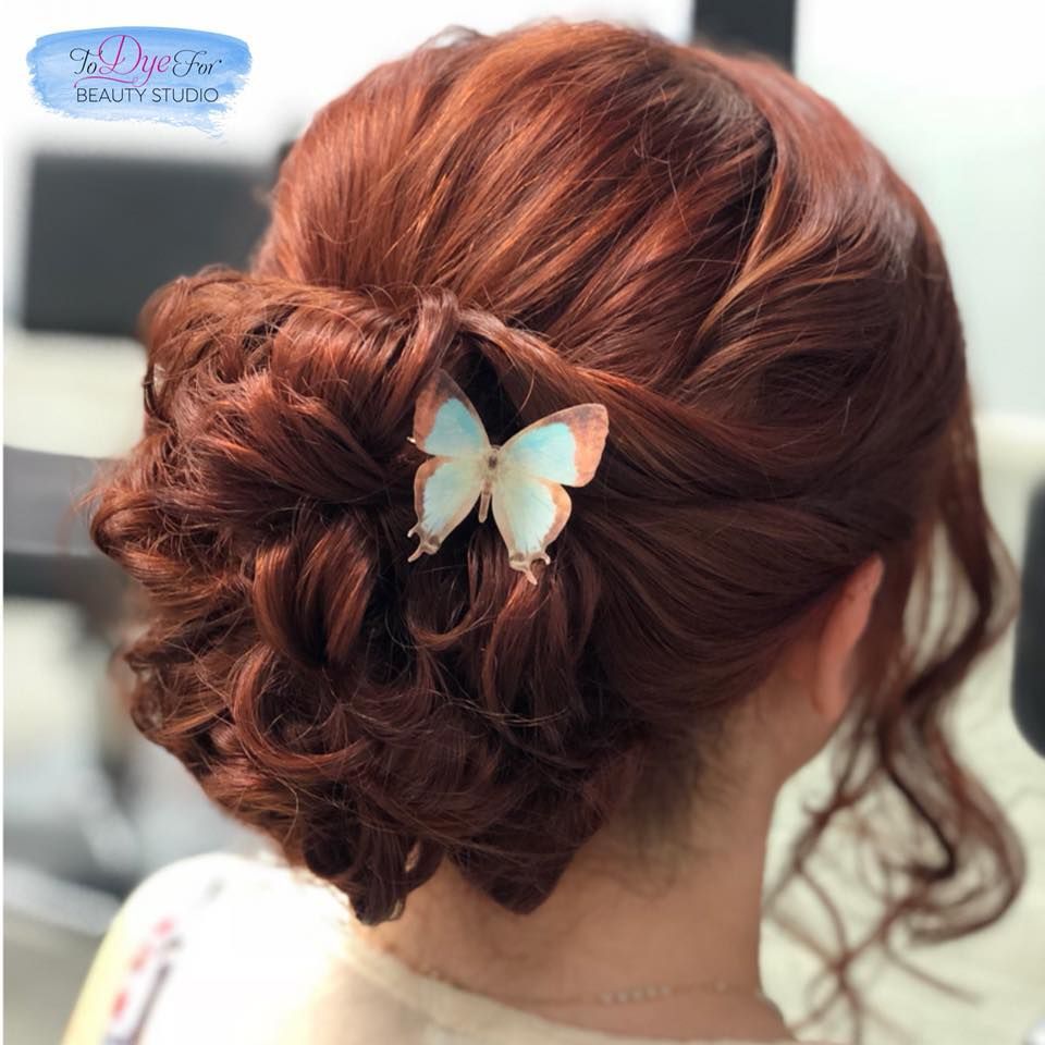 A woman with red hair has a butterfly in her hair