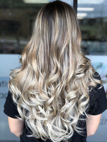 A woman with long blonde hair is wearing a black shirt.