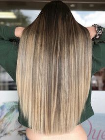 A woman with long hair is wearing a green sweater.