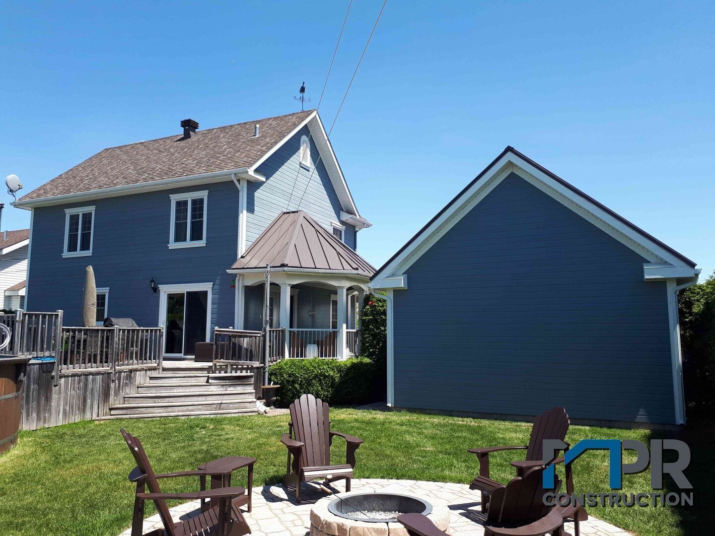 Une maison bleue avec un foyer devant elle