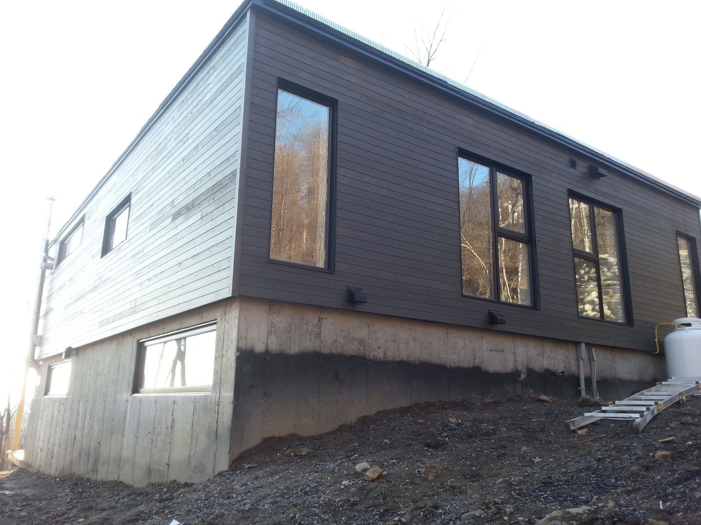 Une maison avec beaucoup de fenêtres est située au sommet d'une colline