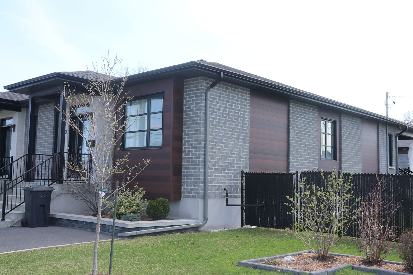 Une maison avec beaucoup de fenêtres et une clôture devant.