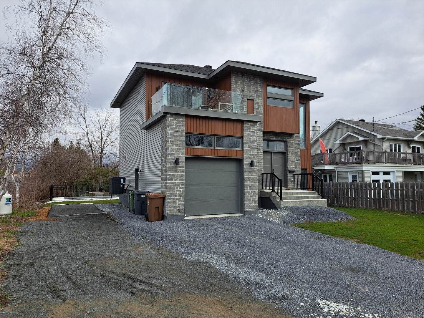 Une maison avec un garage et une allée devant.