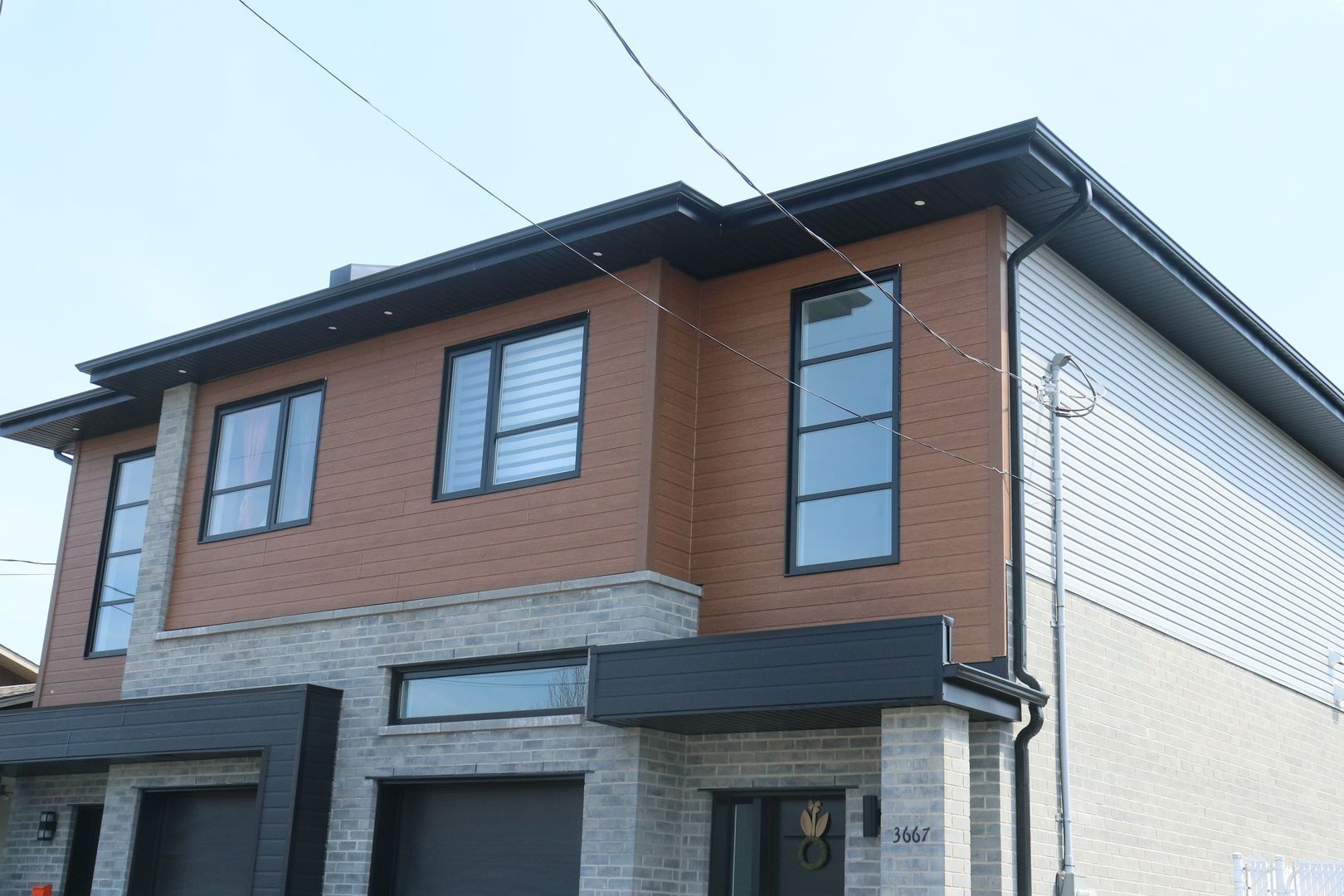 Une grande maison avec beaucoup de fenêtres et un garage