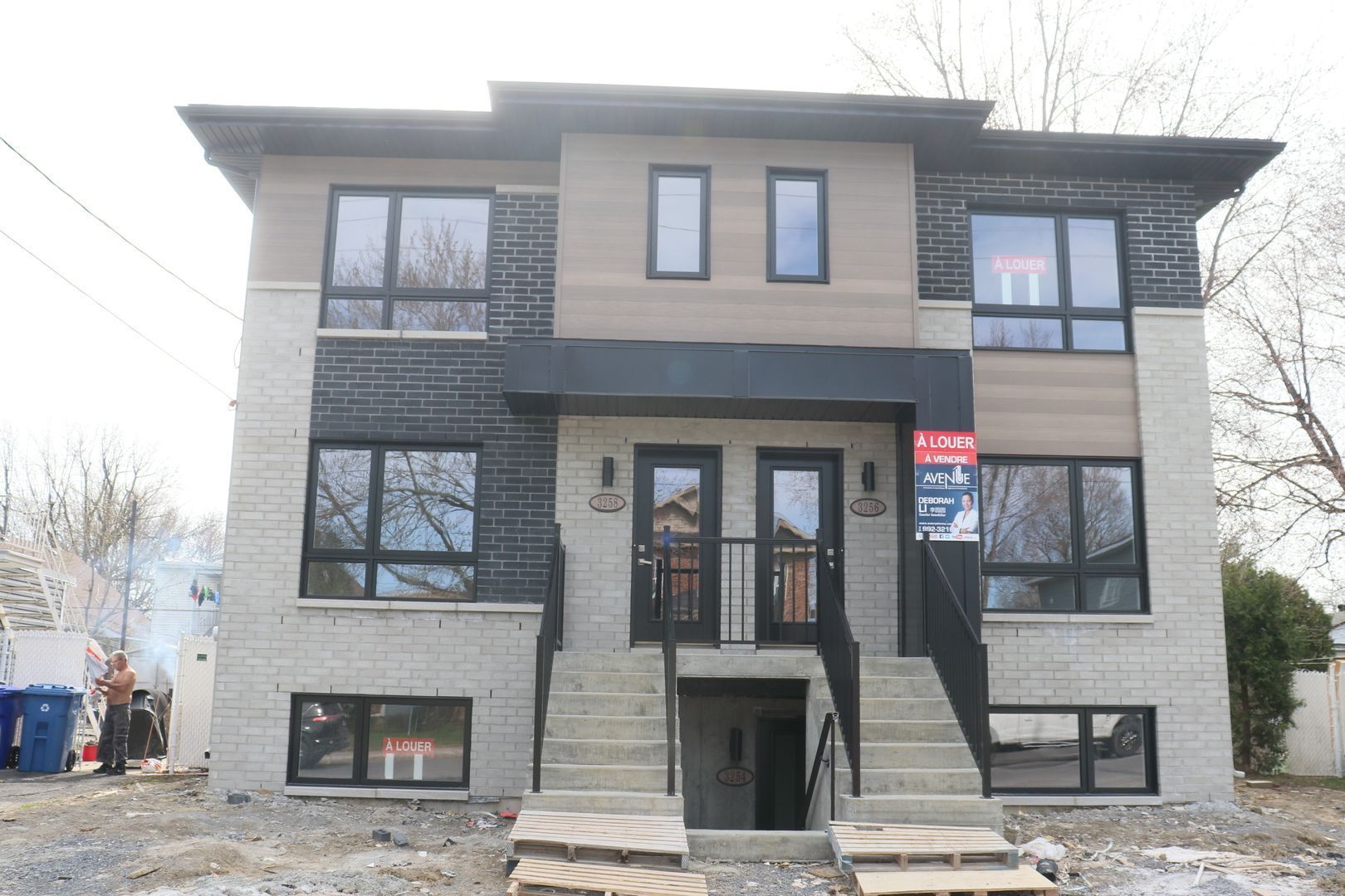 Une grande maison avec beaucoup de fenêtres et d'escaliers est à vendre.