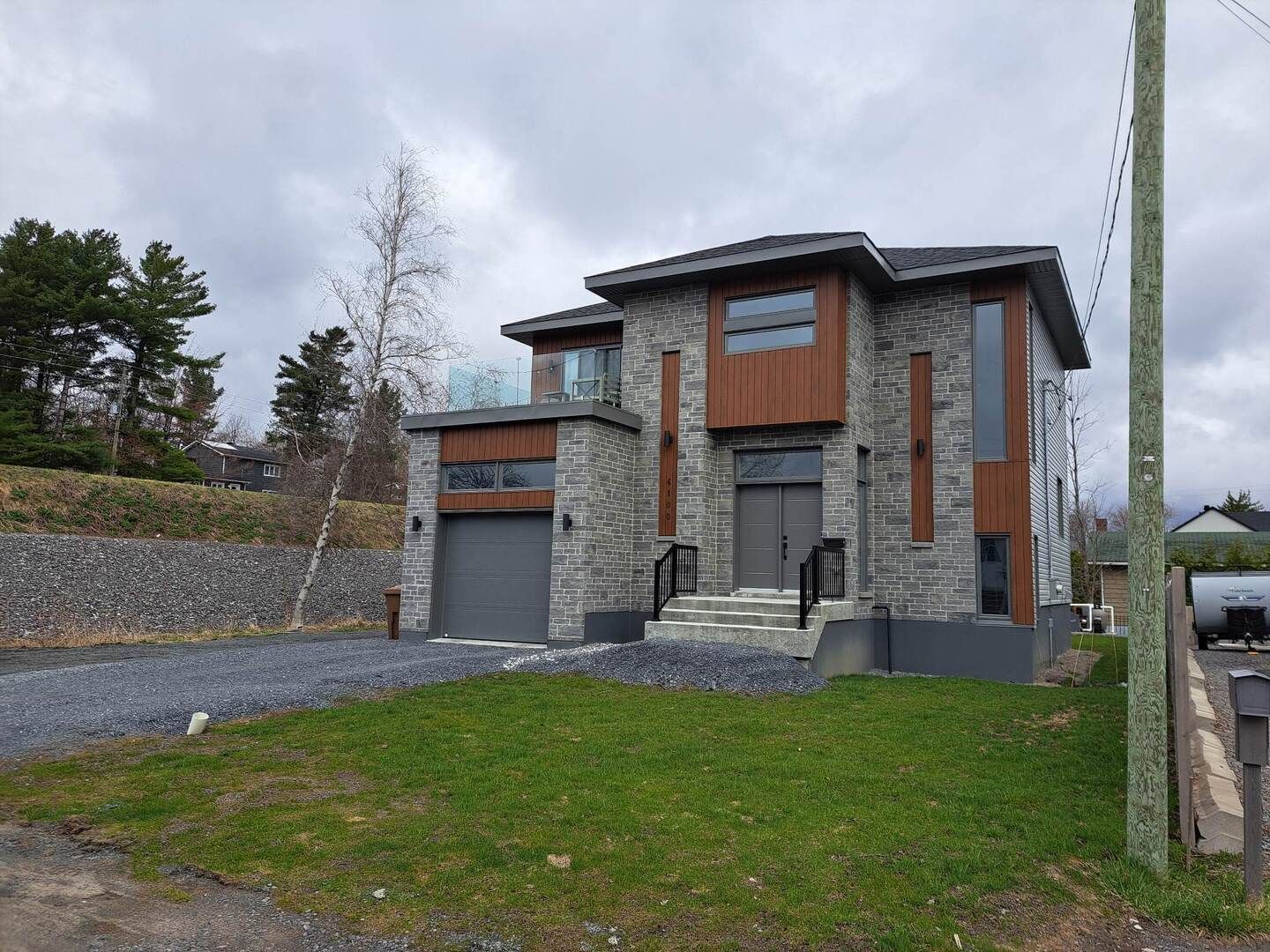 Une grande maison avec un garage et beaucoup d'herbe devant.