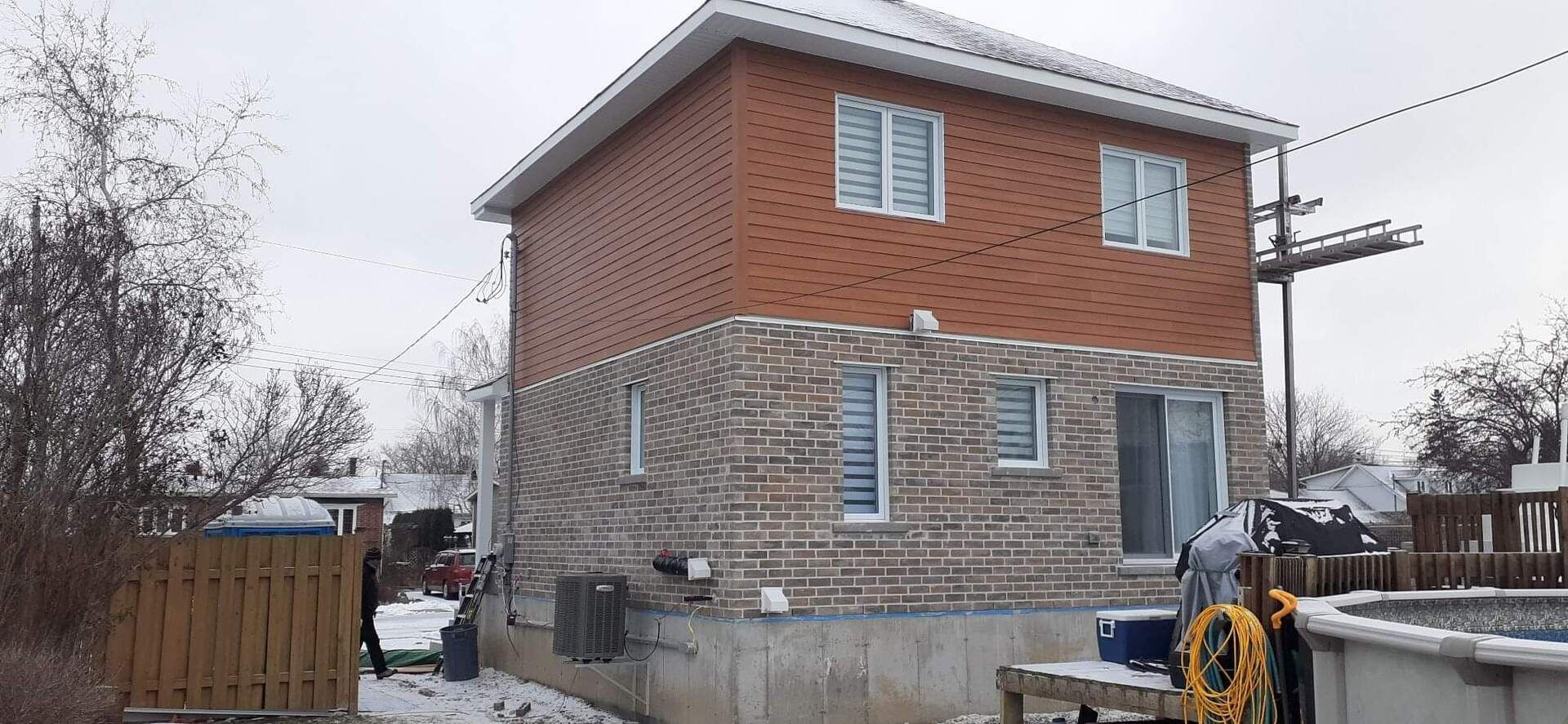 Une grande maison en brique avec une piscine dans l'arrière-cour.