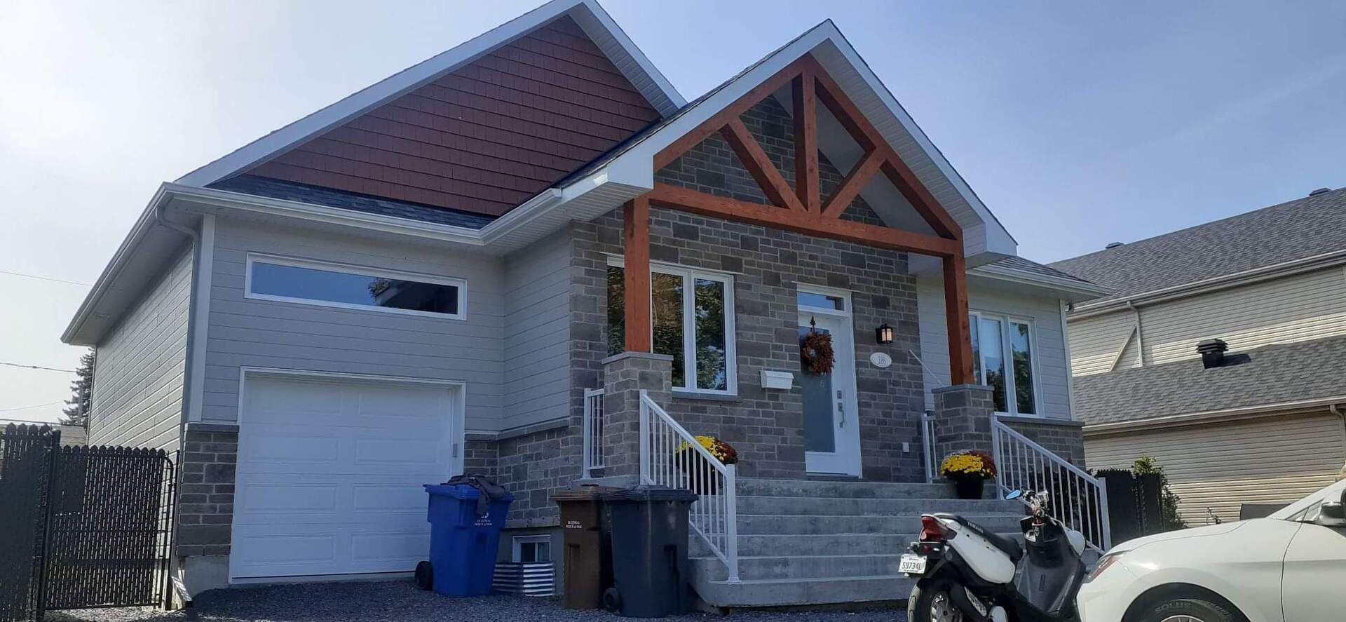 Une maison avec une moto garée devant.