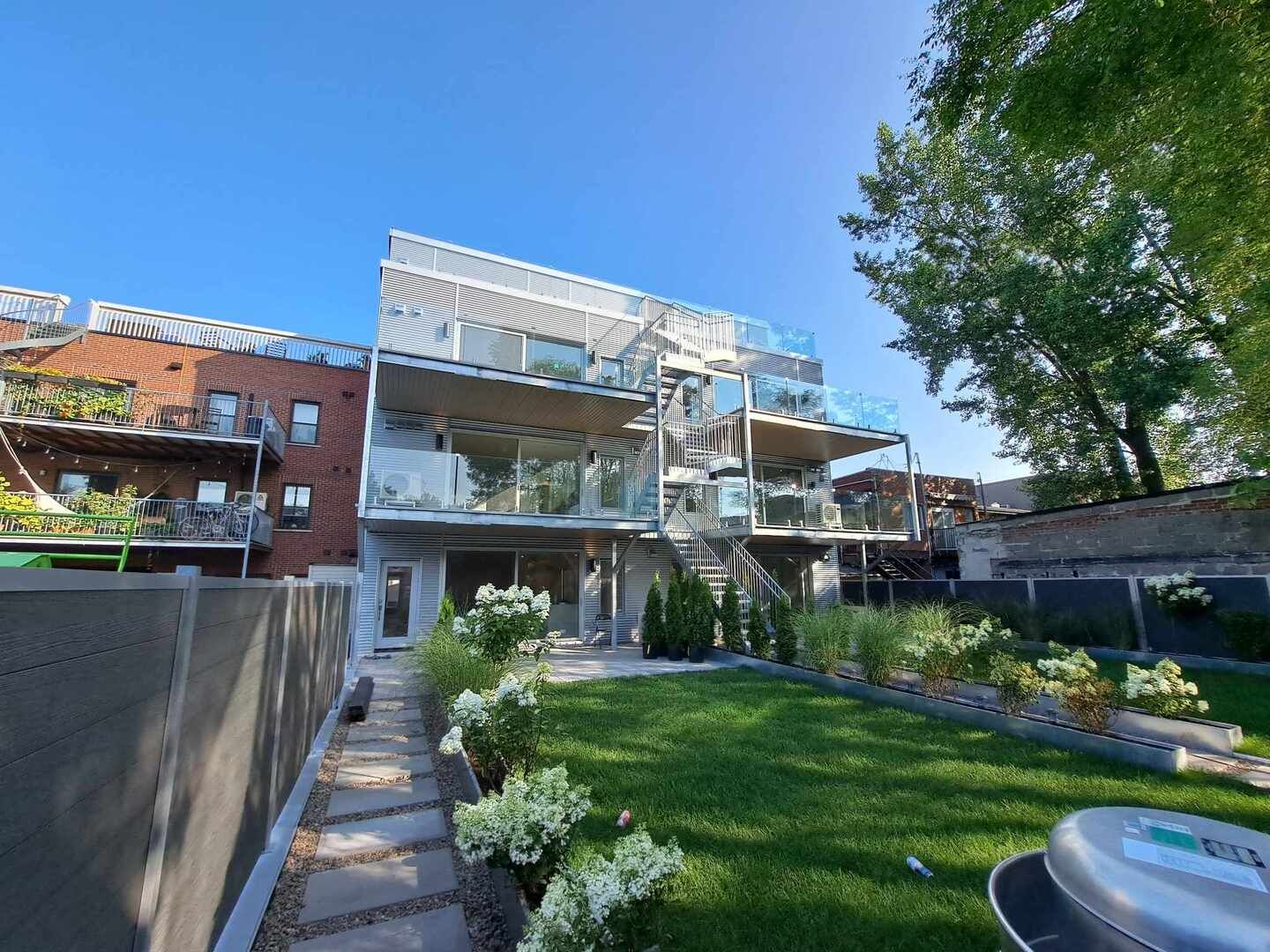 Un grand immeuble d'appartements avec une grande pelouse devant lui.