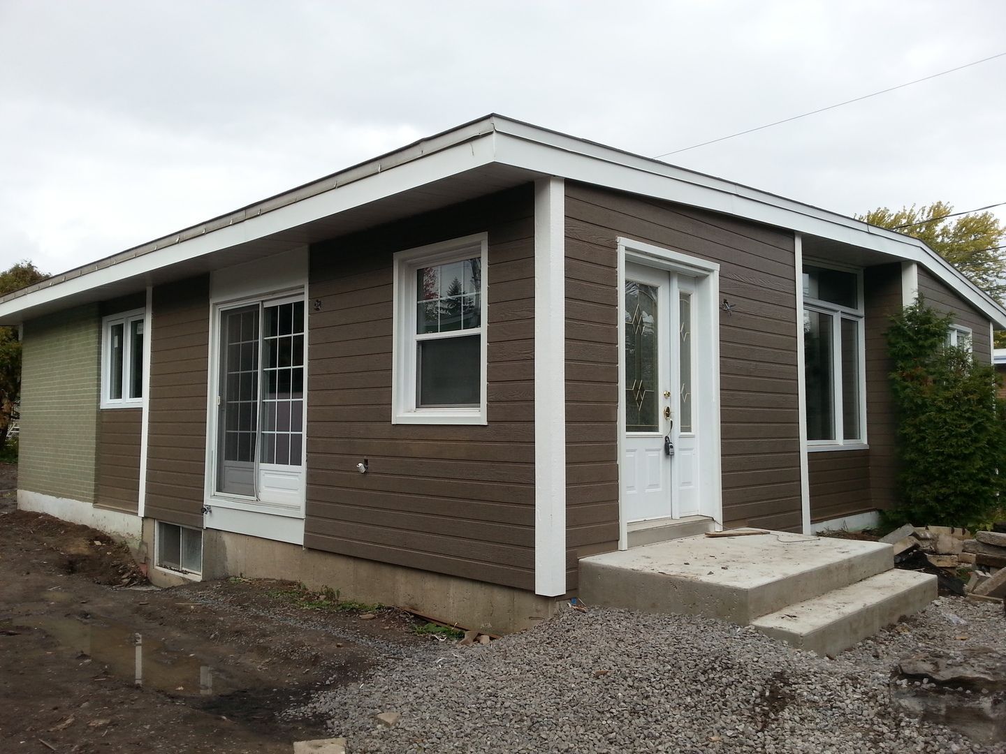 Une petite maison brune avec des bordures et des fenêtres blanches