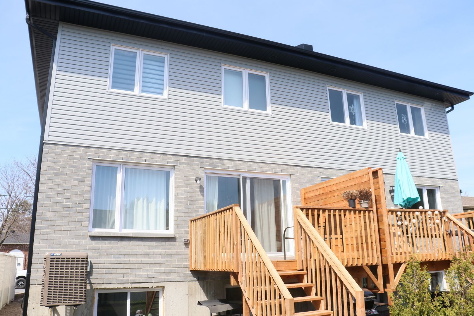 L'arrière d'une maison avec une terrasse en bois et des escaliers