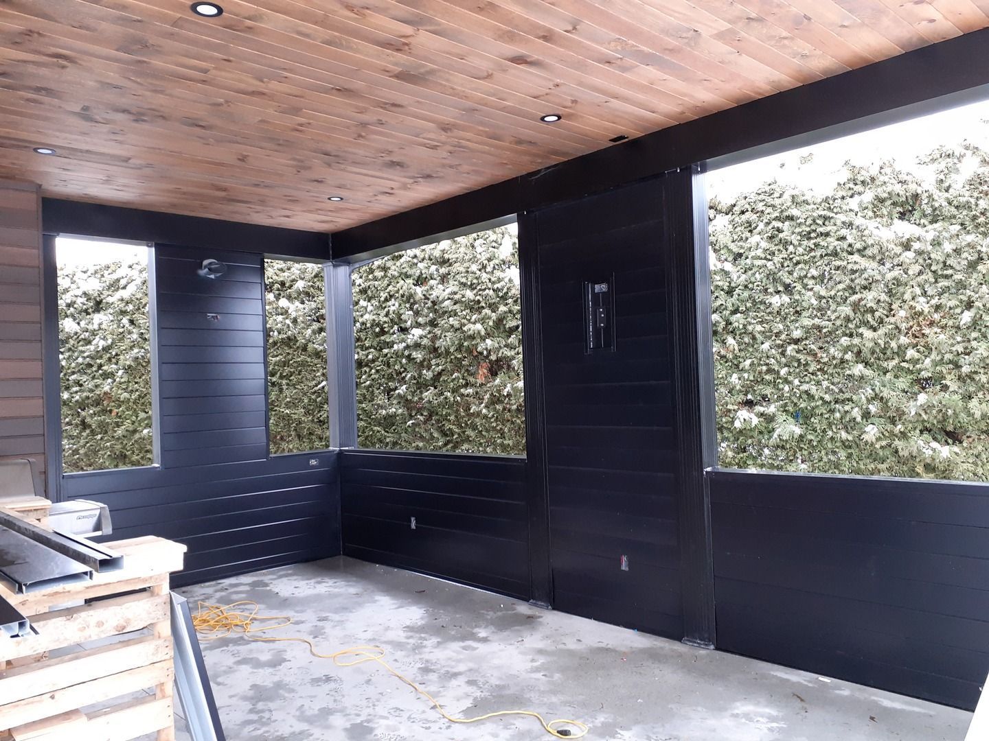 Une pièce avec beaucoup de fenêtres et un plafond en bois.